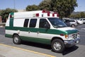 Side and front view of parked green and white ambulance
