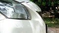 Side of front white car close up on car headlights. Royalty Free Stock Photo