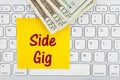 Side gig message with money on a keyboard with sticky note Royalty Free Stock Photo