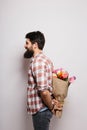 Side Handsome young man with beard and nice bouquet of flowersSide Handsome young man with beard and nice bouquet of flowers Royalty Free Stock Photo