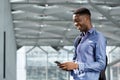 Side of happy young black businessman looking at cellphone Royalty Free Stock Photo