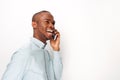 Side of happy young black man talking with cellphone by white background Royalty Free Stock Photo