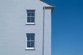 Side of house with blue pastel coloured plain rendered wall Royalty Free Stock Photo