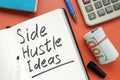 Side hustle ideas list and cash on the desk. Royalty Free Stock Photo