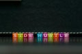 Side hustle phrase made of cube beads of different colors on black background. Concept of additional income Royalty Free Stock Photo