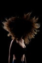 Side lit brunette girl with long curly hair in the air. Silhouette studio portrait on dark background Royalty Free Stock Photo