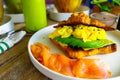 A side look of healthy food - croissant with scramble eggs, sliced avocado, smoked salmons.