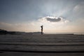 Side low angle view of a woman with arms outspread against cloud Royalty Free Stock Photo