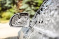 Side mirror of silver car, covered with shampoo and foam, when w