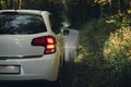 Side mirror turn signal blinker. Turn indicator on the mirror right and white car on the road in autumn dark forest. Royalty Free Stock Photo