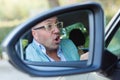 Side mirror view reflection angry mad young man driving his car about to make an accident. Transportation accident concept Royalty Free Stock Photo