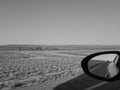 Side mirror view of windmill and truck