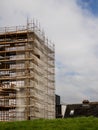 Side of a new building in scaffolding and safety nets. Construction site safety measures. Developing commercial or residential Royalty Free Stock Photo