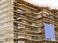 Side of a new building in scaffolding and safety nets. Construction site safety measures. Developing commercial or residential Royalty Free Stock Photo