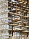 Side of a new building in scaffolding and safety nets. Construction site safety measures. Developing commercial or residential Royalty Free Stock Photo