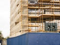Side of a new building in scaffolding and safety nets. Construction site safety measures. Developing commercial or residential Royalty Free Stock Photo