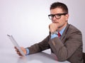 Side of pensive young business man with tablet looking at you Royalty Free Stock Photo