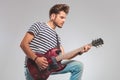 Side photo of artist in studio playing guitar