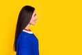 Side photo of brunette hair hispanic young girl wear blue jumper looking empty space haircare product isolated on yellow Royalty Free Stock Photo