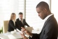 Side portrait of afro american businessman holding smartphone or