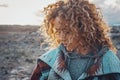 Side portrait of attractive woman with blonde coloured long curly hair looking down and enjoying outdoors nature feeling. Travel Royalty Free Stock Photo