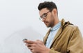 Side portrait of Caucasian man wear eyeglasses and coat, walking outdoor in foggy weather, messaging via social networks at smart Royalty Free Stock Photo