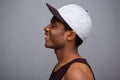 Side portrait of cool african american guy with cap against gray wall Royalty Free Stock Photo