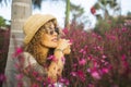 Side portrait of cute young woman smiling and enjoying garden flowers and nature feeling in spring season. Happy female people Royalty Free Stock Photo