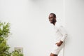 Side of handsome african american man smiling leaning against white wall Royalty Free Stock Photo