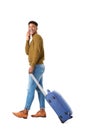 Side of happy young african american travel man walking with mobile phone and suitcase against isolated white background Royalty Free Stock Photo