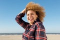 Side portrait of happy young african american woman laughing at the beach with hand in hair Royalty Free Stock Photo