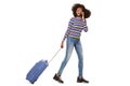 Side portrait of happy young black woman walking with cellphone and suitcase against isolated white background Royalty Free Stock Photo