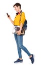 Side portrait of happy young woman walking with bag, books and looking at mobile phone Royalty Free Stock Photo