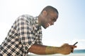 Side portrait smiling african american man using cellphone outside Royalty Free Stock Photo