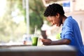 Smiling african american woman reading text message on mobile phone at cafe Royalty Free Stock Photo