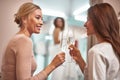 Smiling ladies sitting in showroom with champagne Royalty Free Stock Photo