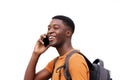 Side portrait of young black man laughing and talking on cellphone against white wall Royalty Free Stock Photo