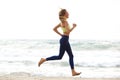 Young sport woman running by water ion beach Royalty Free Stock Photo