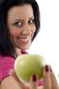 Side pose of pleased female offering apple Royalty Free Stock Photo
