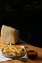 A side of potato fries with tomato sauce and cheese.