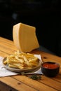 A side of potato fries with tomato sauce and cheese.