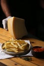 A side of potato fries with tomato sauce and cheese.