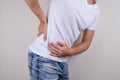 Side profile close up studio photo portrait of unhappy sad upset worried guy touching low body part with hand isolated on grey bac