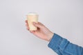 Side profile cropped close up photo of hand holding tasty delicious cup of ice cream isolated grey background