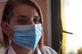 Side profile of a female doctor wearing a white stethoscope lab coat and protective mask for covid 19 Royalty Free Stock Photo