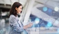 Side profile of a happy businesswoman using her smartphone in an airport lounge Royalty Free Stock Photo