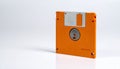 Side Profile of Orange 3.5 Inch Floppy Disk with Metal Shutter and Hub on White Surface Royalty Free Stock Photo
