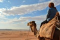 side profile of person atop camel with expansive desert horizon Royalty Free Stock Photo