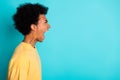 Side profile photo of angry man with afro hairstyle wear oversize t-shirt loud scream look empty space isolated on teal