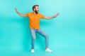 Side profile photo of handsome positive man muscular beard wear orange t-shirt jeans look empty space isolated on teal